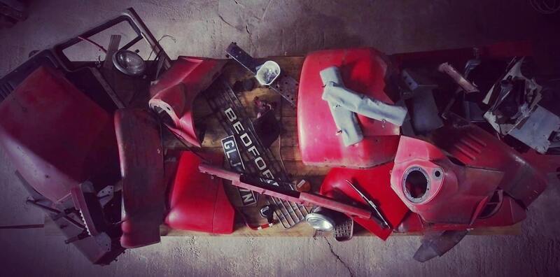 Aerial view of a workbench piled up with the parts of a Bedford truck