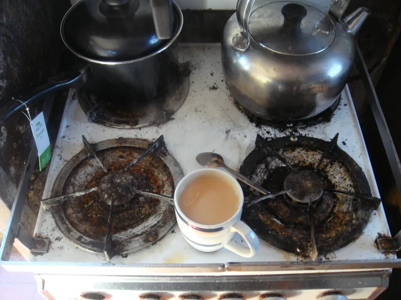 Mug of tea on a dirty cooker top inside a fishing trawler