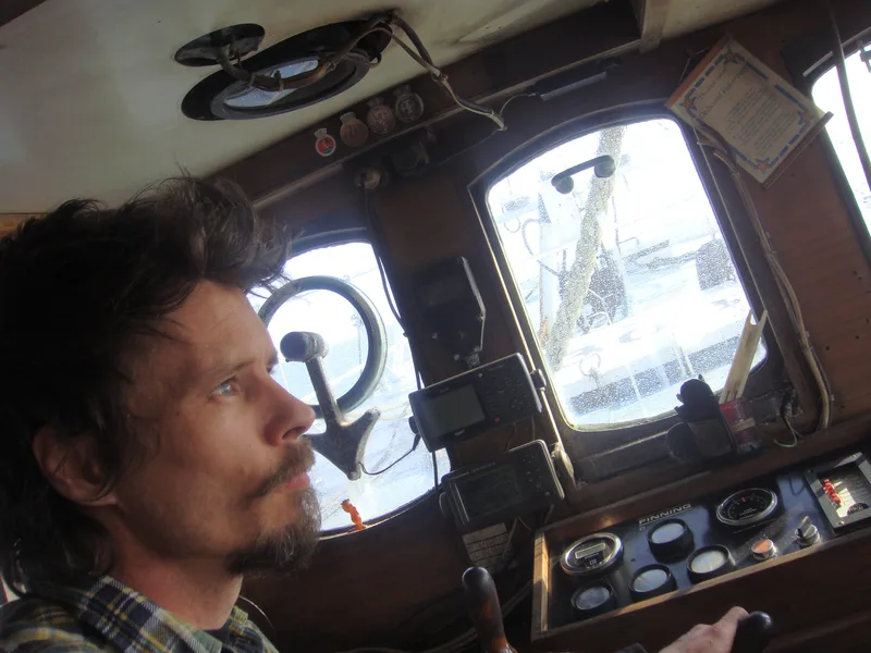Man inside the wheelhouse of a fishing trawler