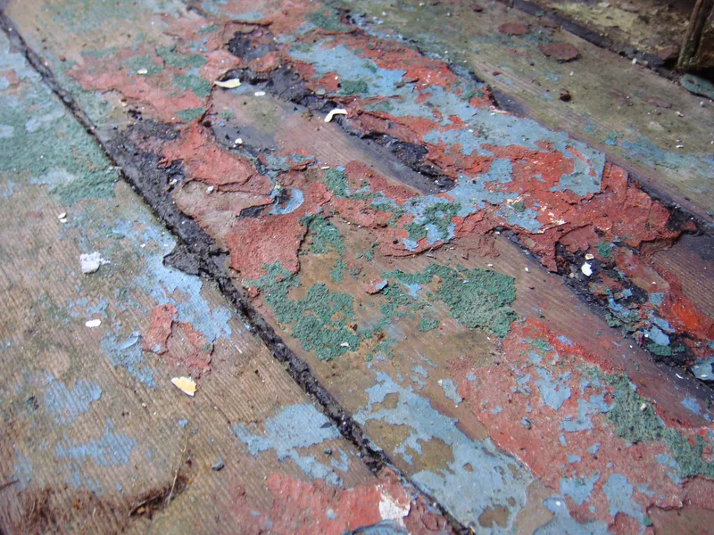 Peeling paint on wooden floorboards