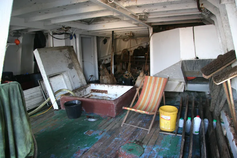 Under the shelter deck of a wooden fishing trawler