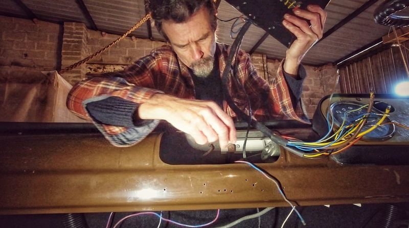 Man fitting some wiring in to the cab of a Bedford truck